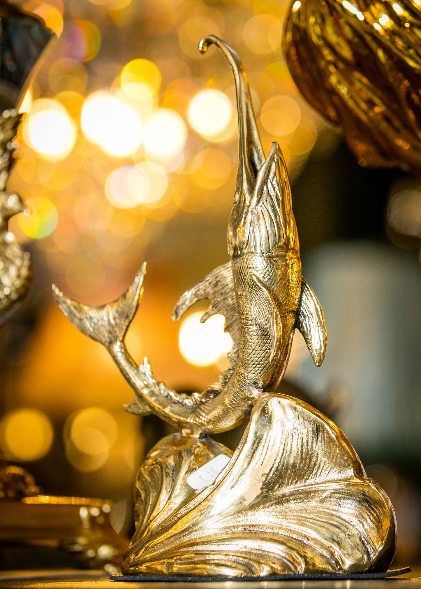 Detailed view of the solid brass swordfish statue displayed in a luxury nautical setting