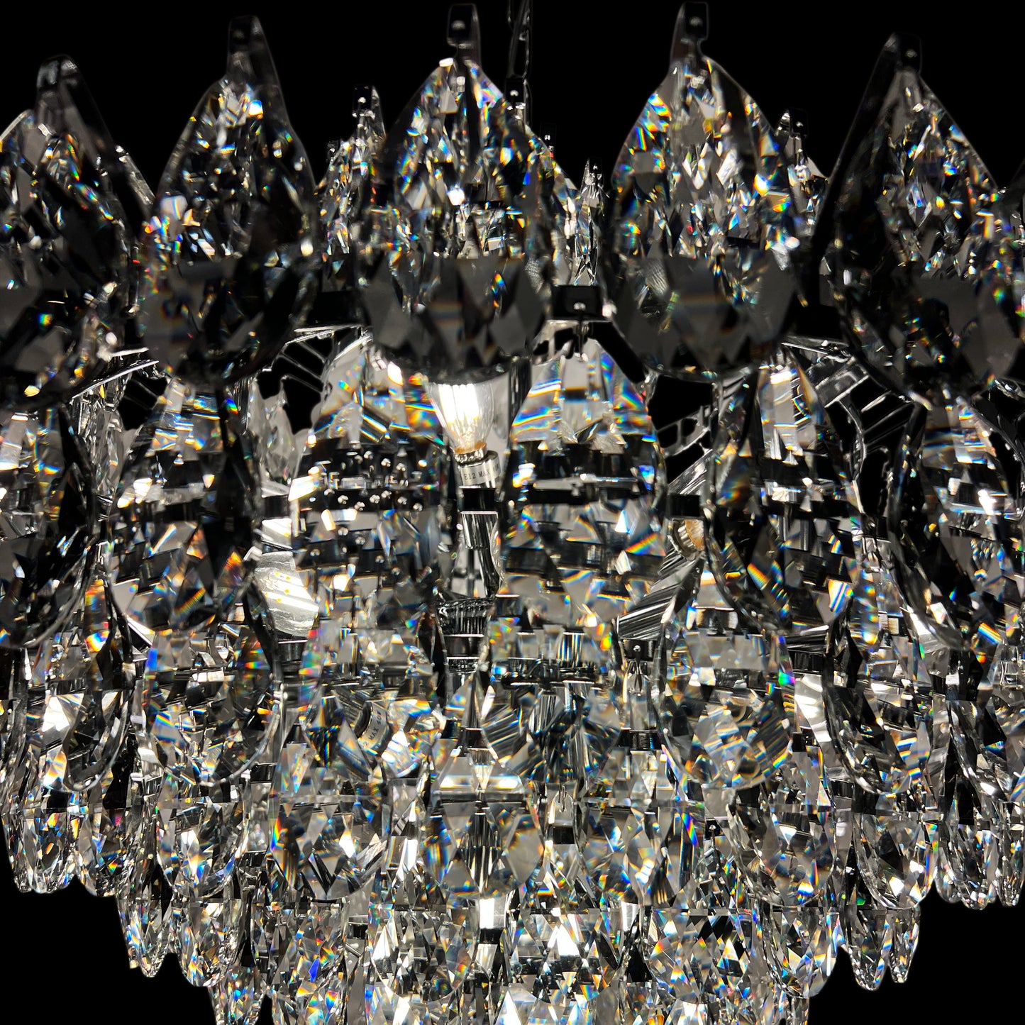 Detailed close-up of chrome crystal chandelier with reflective luxury tear drop crystals.