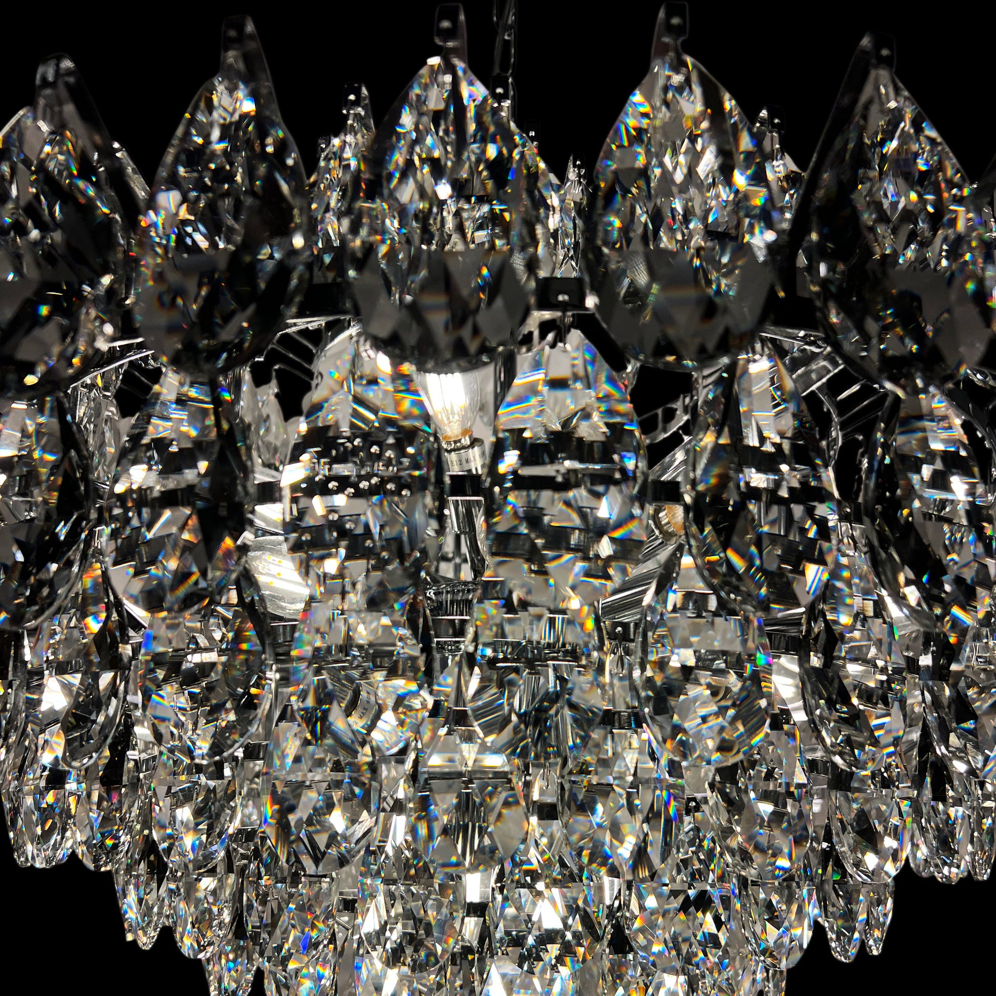 Detailed close-up of chrome crystal chandelier with reflective luxury tear drop crystals.