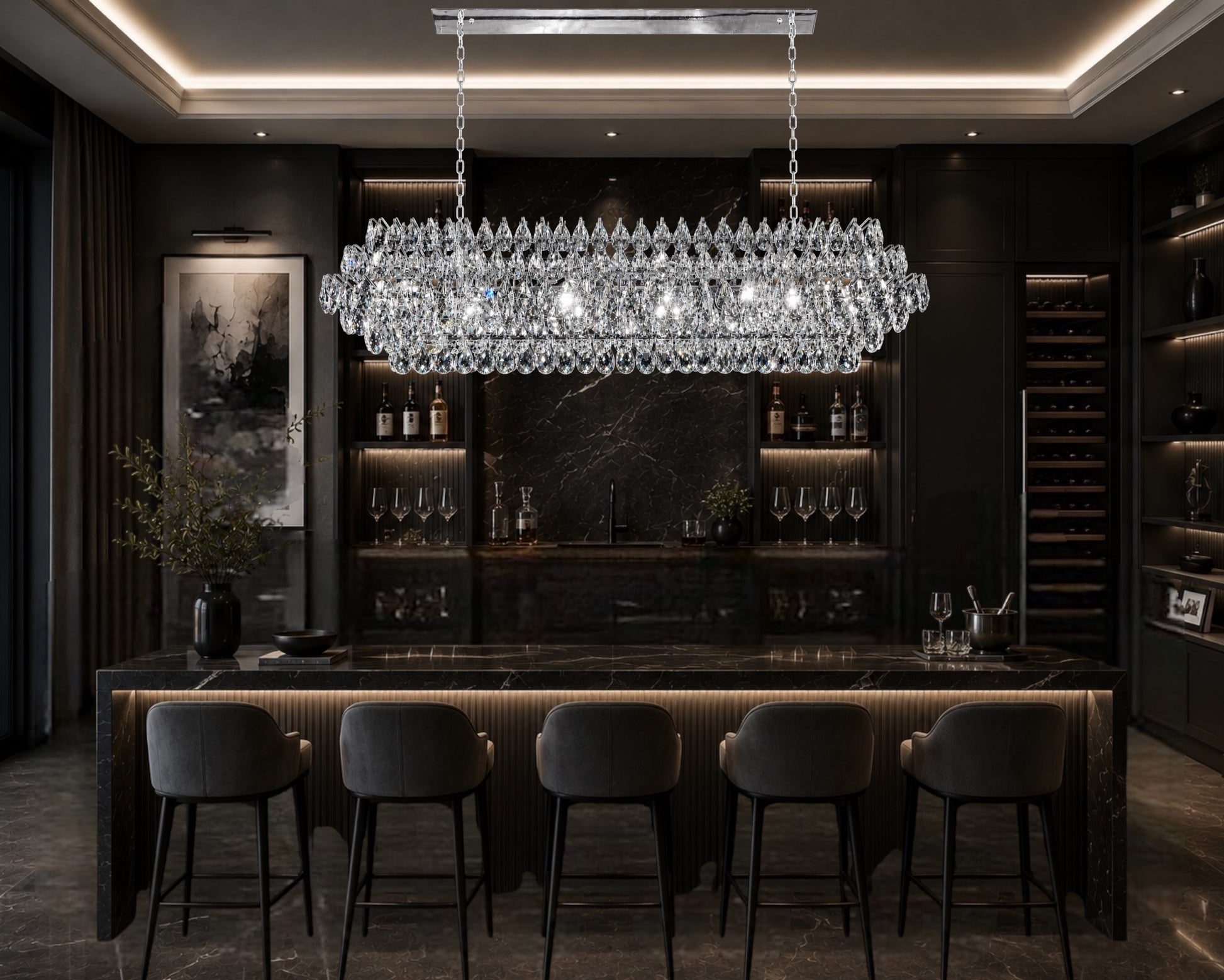 An elegant linear crystal chandelier with a Chrome frame hanging above a luxury home bar counter, illuminating sleek velvet bar stools, a black marble countertop, and a fully stocked back bar with warm accent lighting.