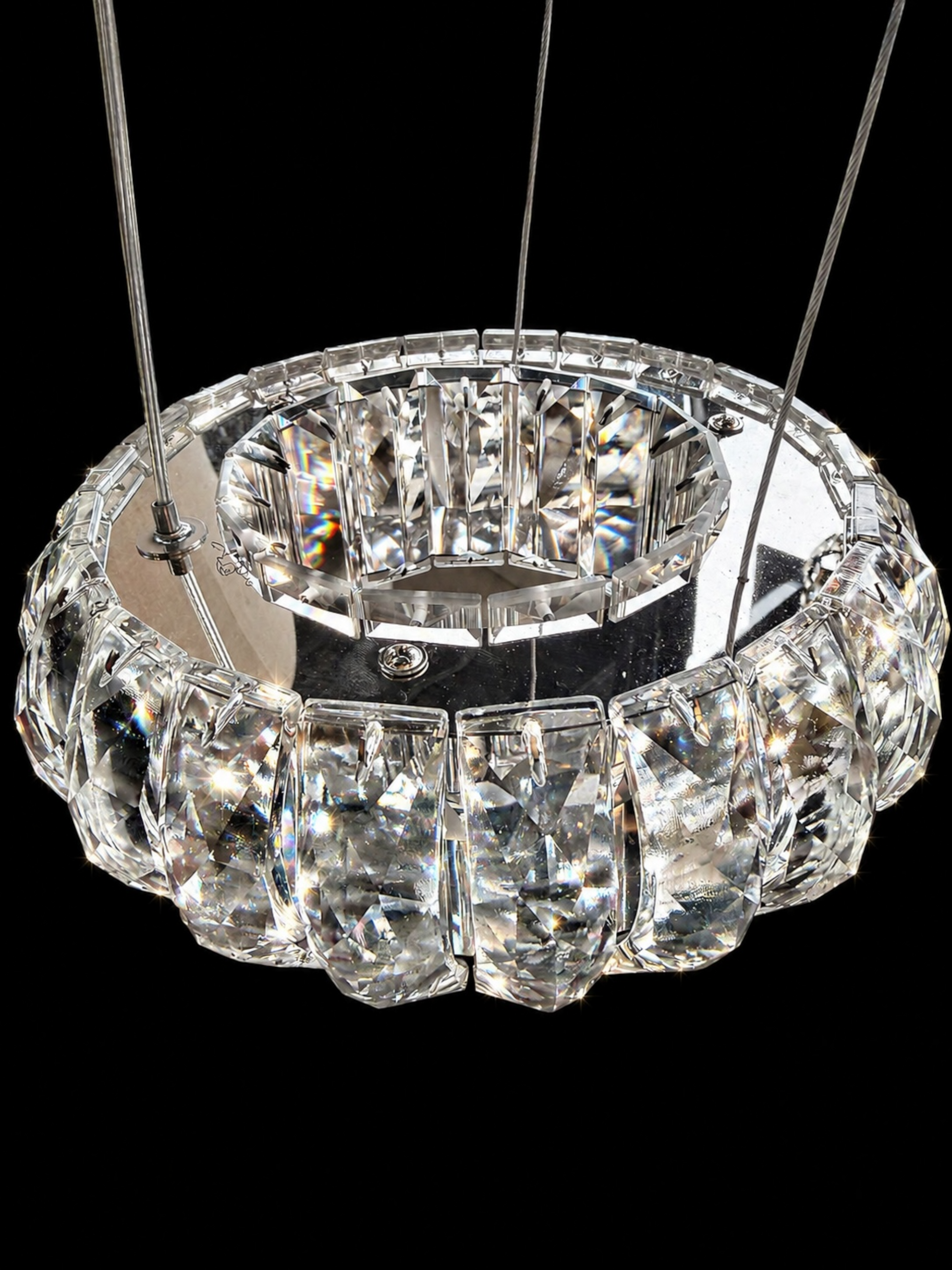 Crystal chandelier with clear glass and metal frame on a black background