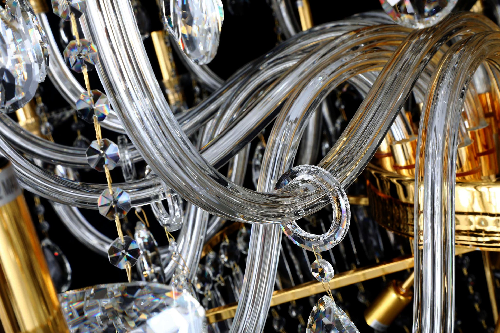 Detailed view of curved crystal arms and gold fittings of the empire chandelier.