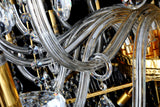Detailed view of curved crystal arms and gold fittings of the empire chandelier.