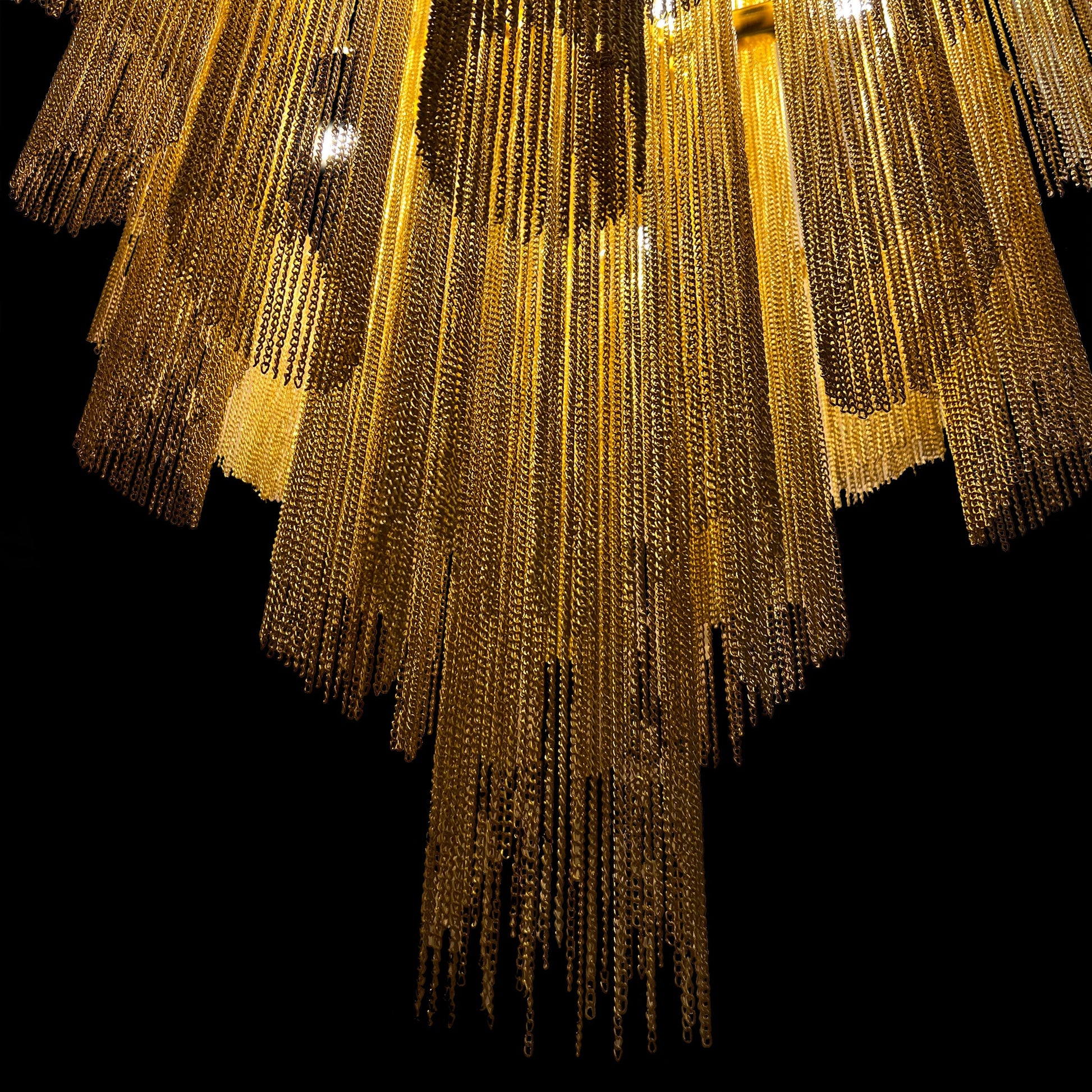 Close-up view showing the polished gold finish and cascading metallic chains of the luxury waterfall chandelier.
