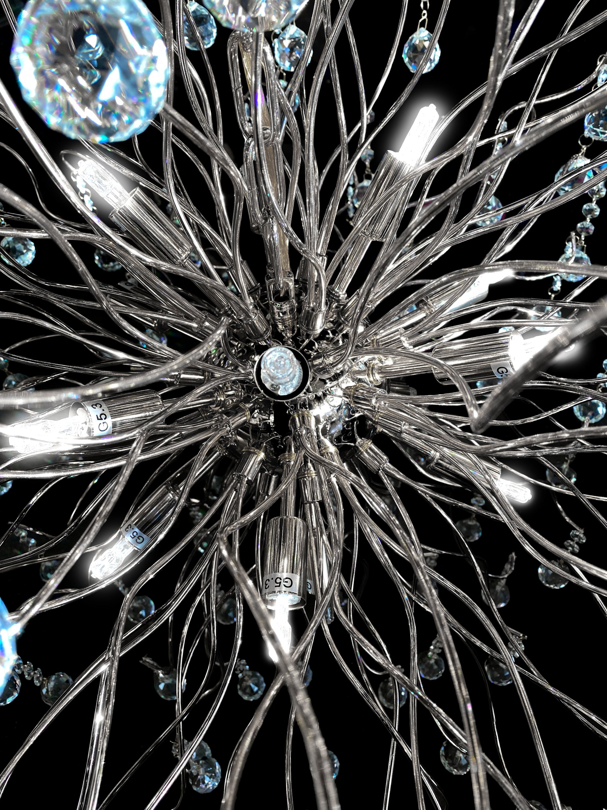 Close-up chrome view of sparkling crystal drops and stainless steel branches.