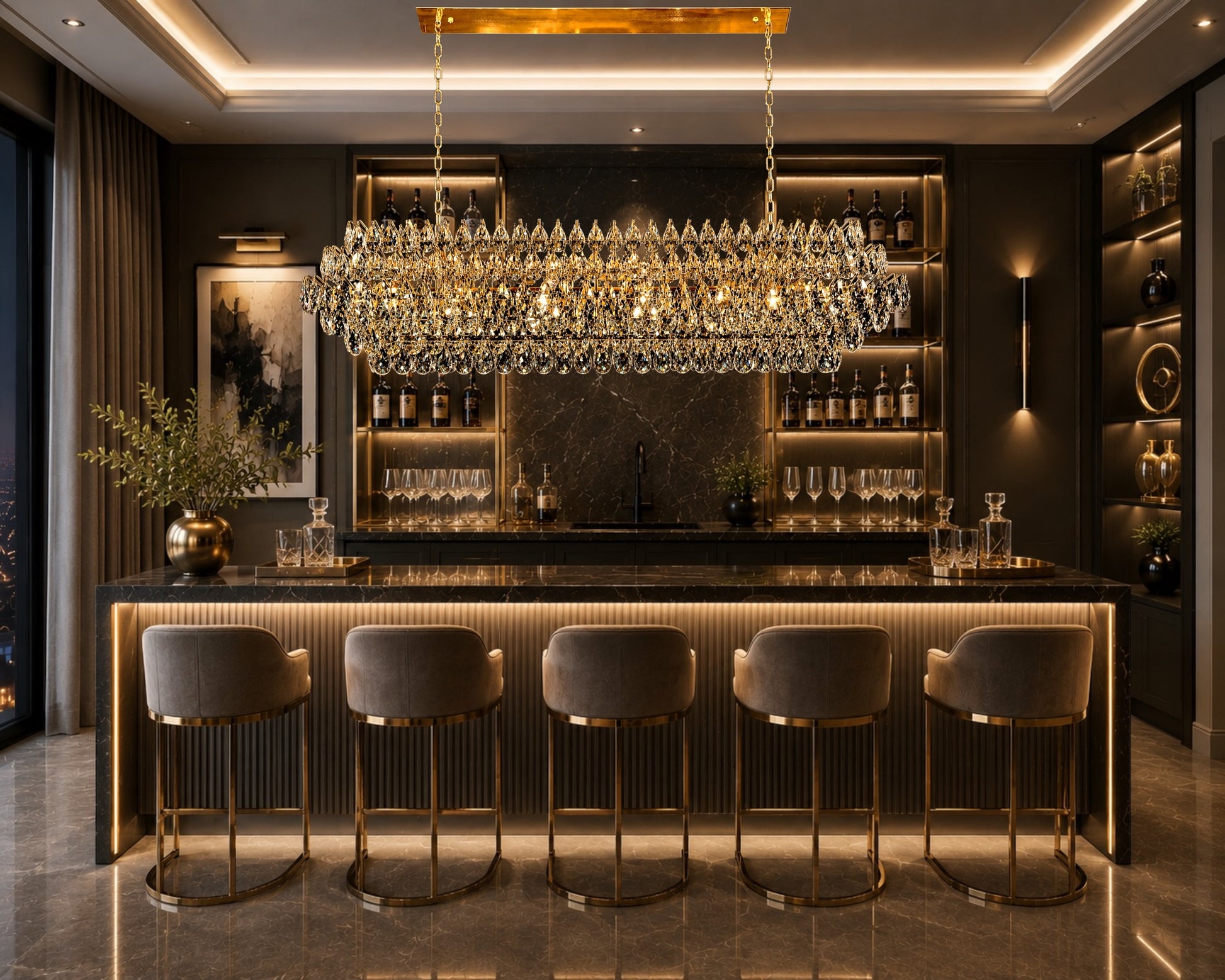 An elegant linear crystal chandelier with a champagne gold frame hanging above a luxury home bar counter, illuminating sleek velvet bar stools, a black marble countertop, and a fully stocked back bar with warm accent lighting.