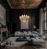 Elegant gold crystal chandelier with pleated fabric shades illuminating a classic living room with dark walls and refined décor.