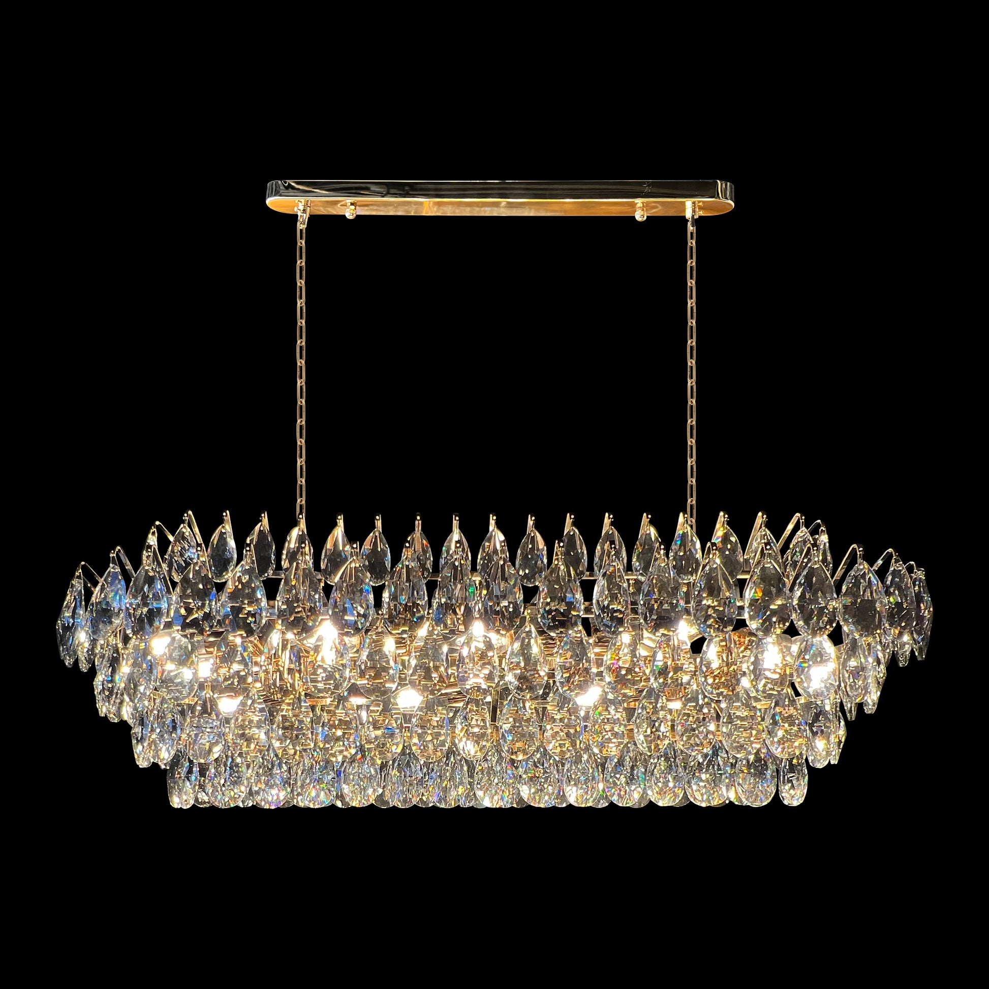 Champagne gold rectangular crystal chandelier with teardrop K9 crystals and empire-style linear design on a black background.