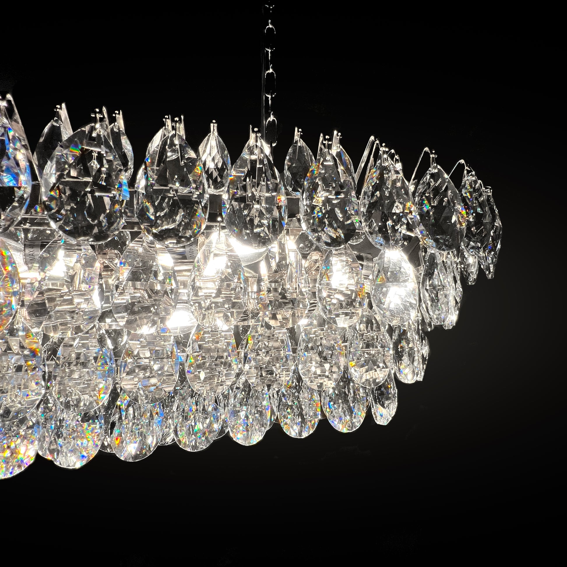 Chrome crystal linear chandelier creating a refined ambiance above a contemporary dining table.