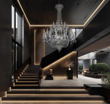 Elegant chrome crystal chandelier illuminating a modern foyer with grand ceilings.
