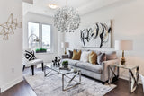 Chrome crystal halo chandelier illuminating a modern living room interior