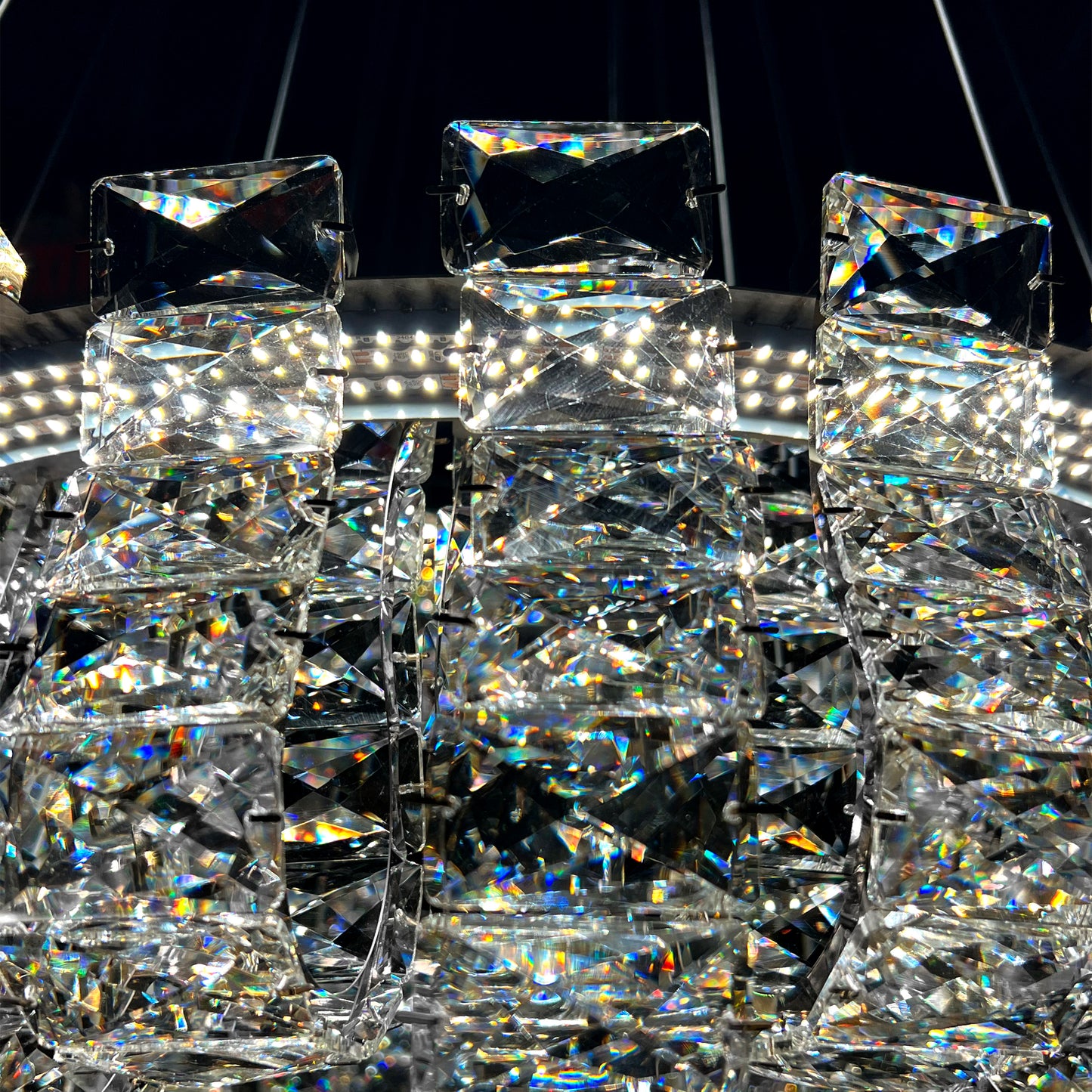 Closeup of luxury K9 crystal chandelier showing intricate silver frame and reflective crystal details.

