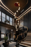 Tall LED gold cascading crystal chandelier lighting a modern foyer and staircase