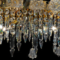 Detailed view of glass crystal drops and gold plated base of luxury Baccarat style chandelier with artisanal craftsmanship.
