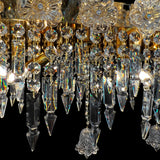 Detailed view of glass crystal drops and gold plated base of luxury Baccarat style chandelier with artisanal craftsmanship.
