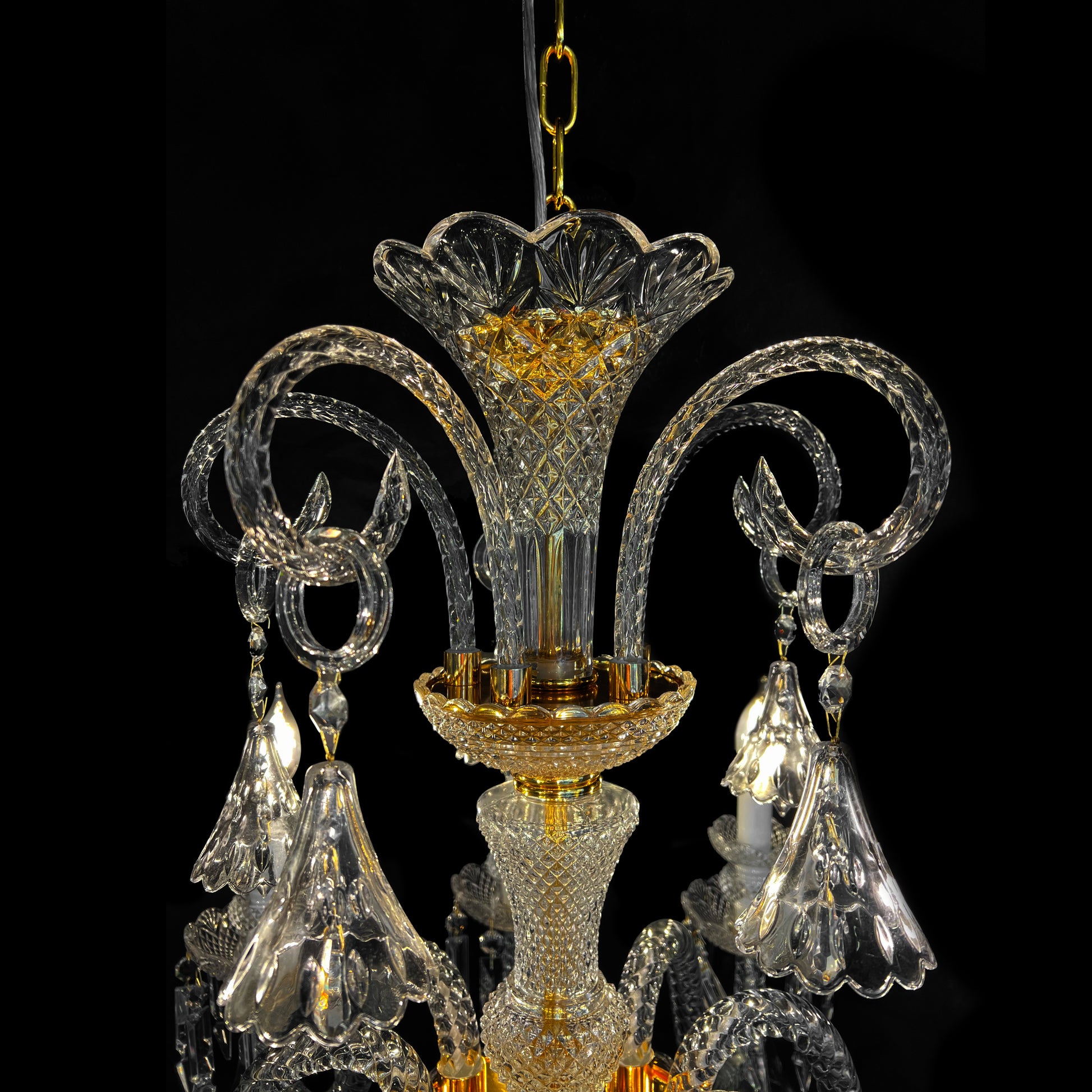 Close-up of a luxury gold and crystal chandelier showing fine glass craftsmanship, baroque detailing, and sparkling crystal