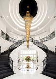 Elegant gold crystal chandelier illuminating grand staircase.