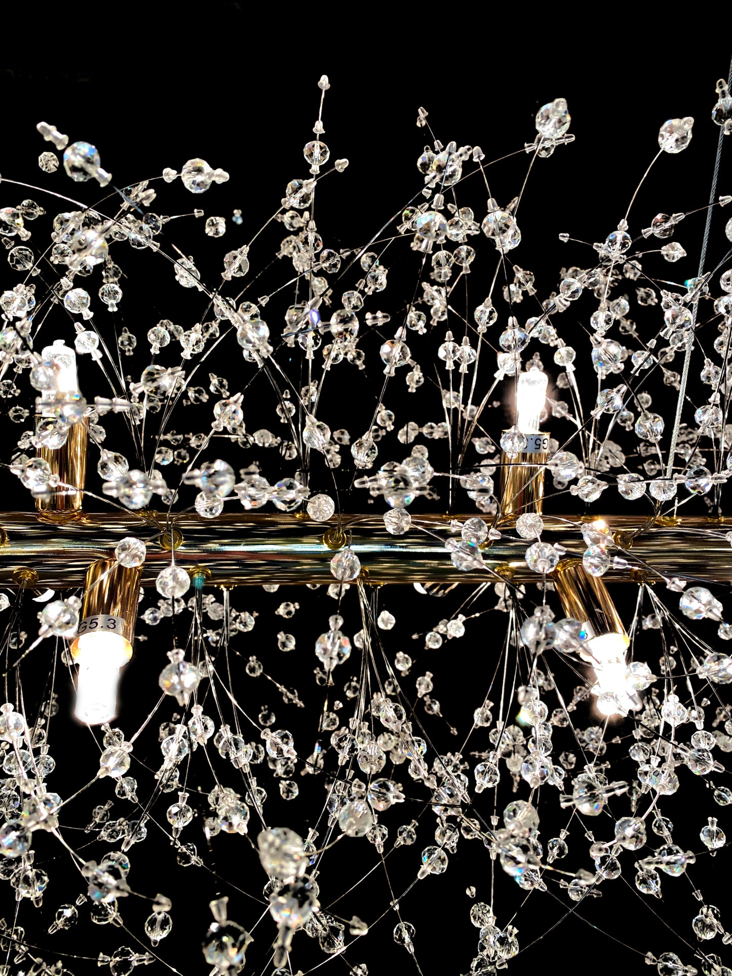 Detailed close-up of chrome starburst chandelier with sparkling crystals
