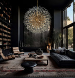 A luxurious gold crystal starburst chandelier hanging in a well-lit room with high ceilings, featuring a sophisticated design with sparkling nano-cut crystal beads.