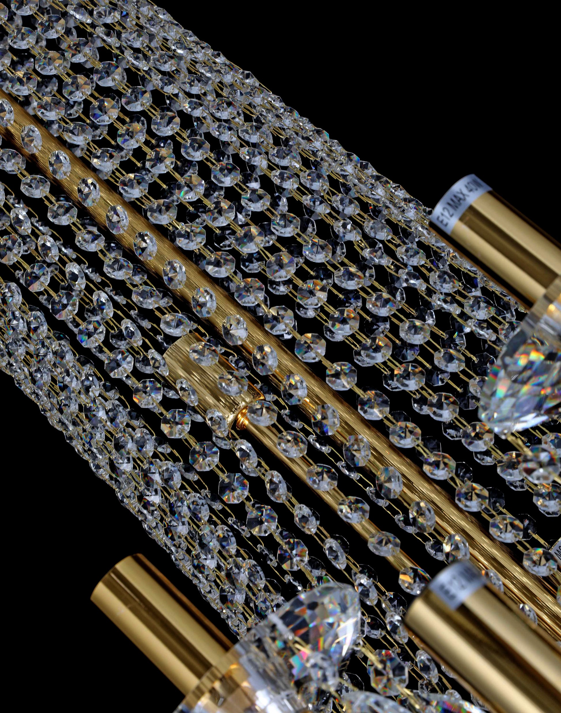 Close-up of precision-cut crystal strands and gold accents in a luxury chandelier.