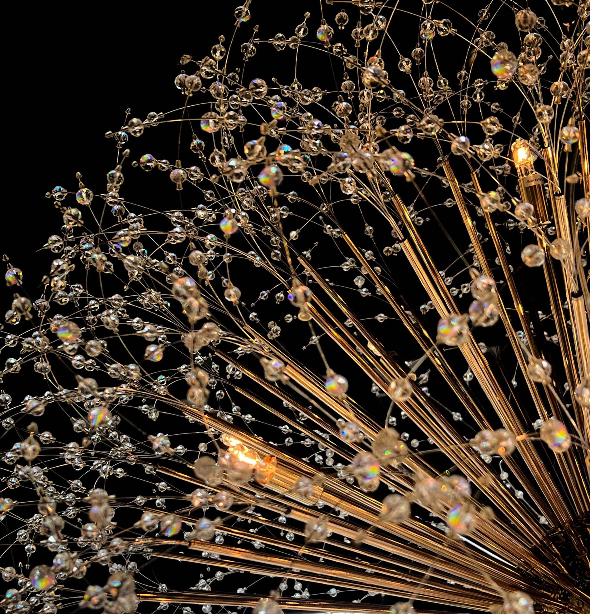 Luxury gold chandelier with crystal arms and sculptural starburst form