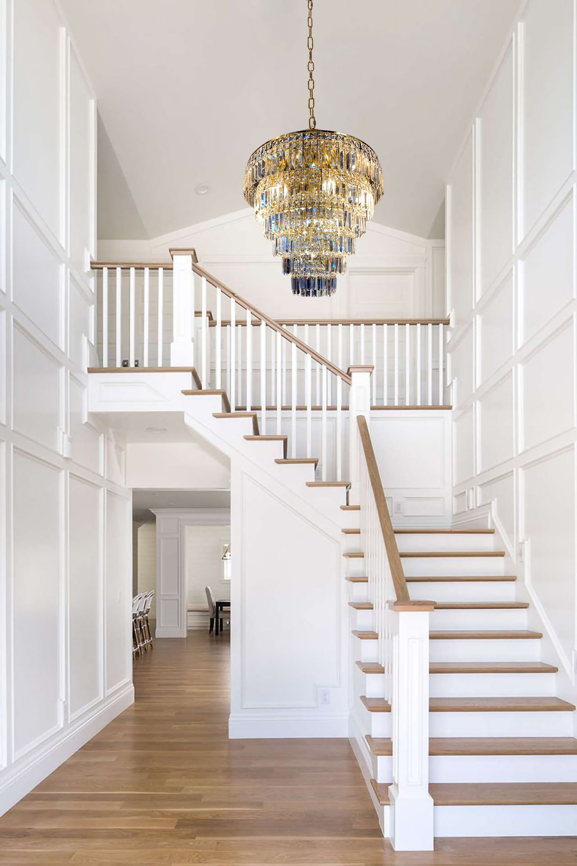 Modern gold tiered crystal chandelier illuminating staircase interior