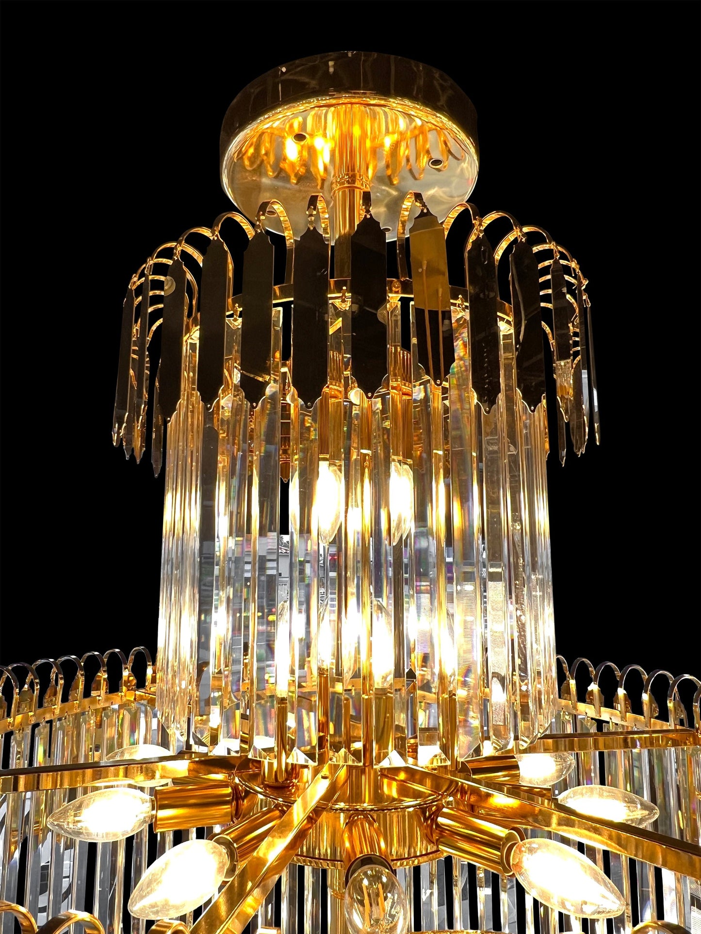 Close-up view of luxury gold crystal chandelier showcasing radiant tiered crystal prisms.