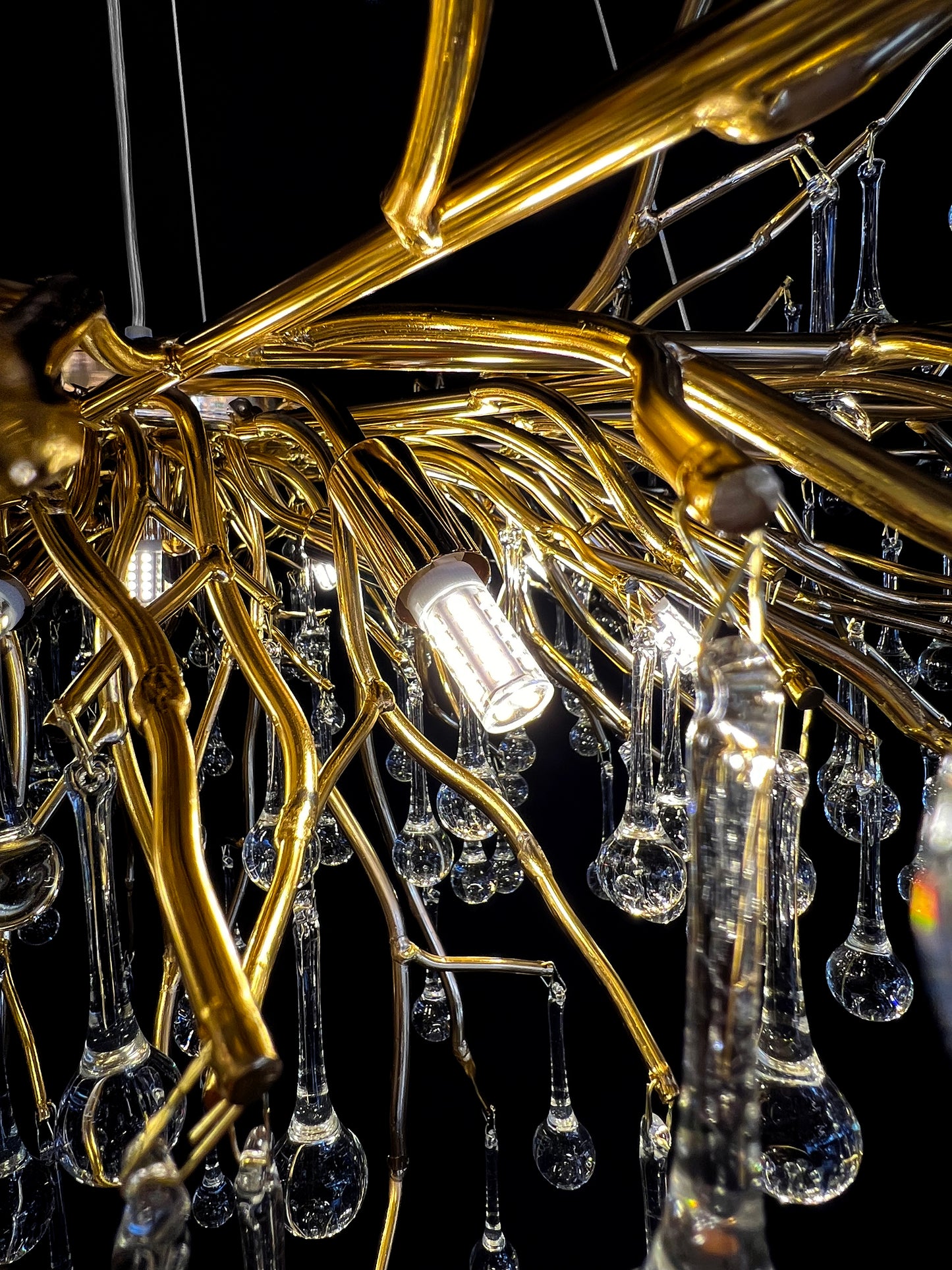 Side angle of gold branch chandelier showing glass reflections with G9 LED bulbs