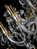 Upper section of chandelier featuring curved gold arms and tear drop crystal 