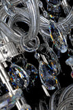 Close-up of chrome crystal chandelier featuring tiered crystal strands and reflective brilliance.