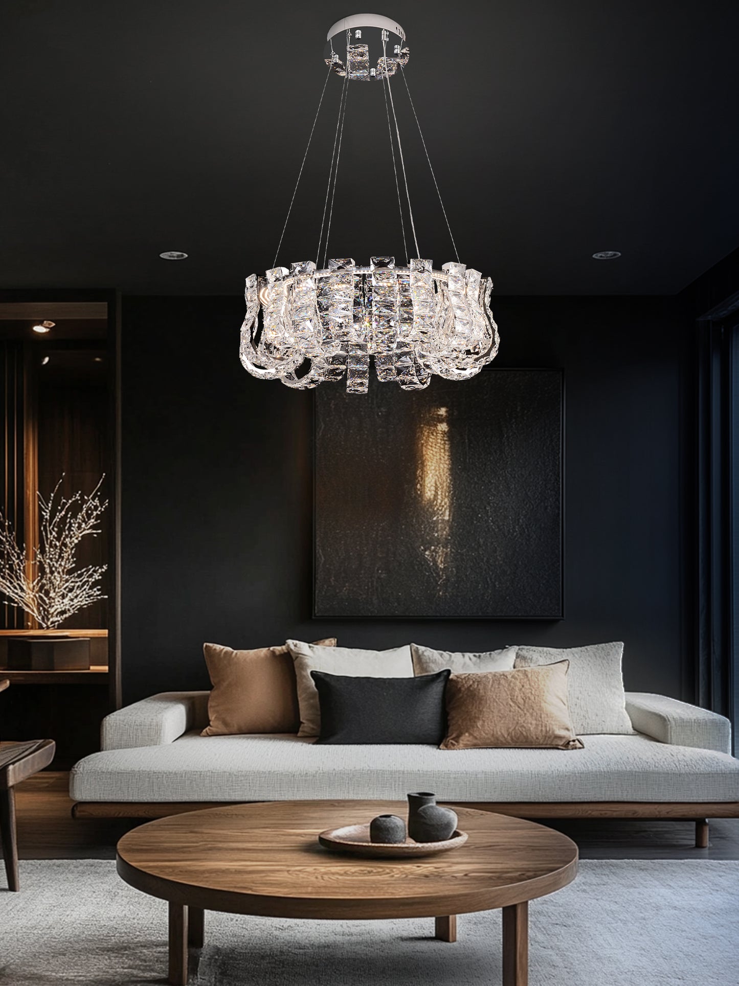 chrome dimmable crystal LED chandelier illuminating a luxury living room with modern décor and dark walls.
