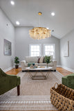 Elegant gold LED chandelier illuminating contemporary family  room