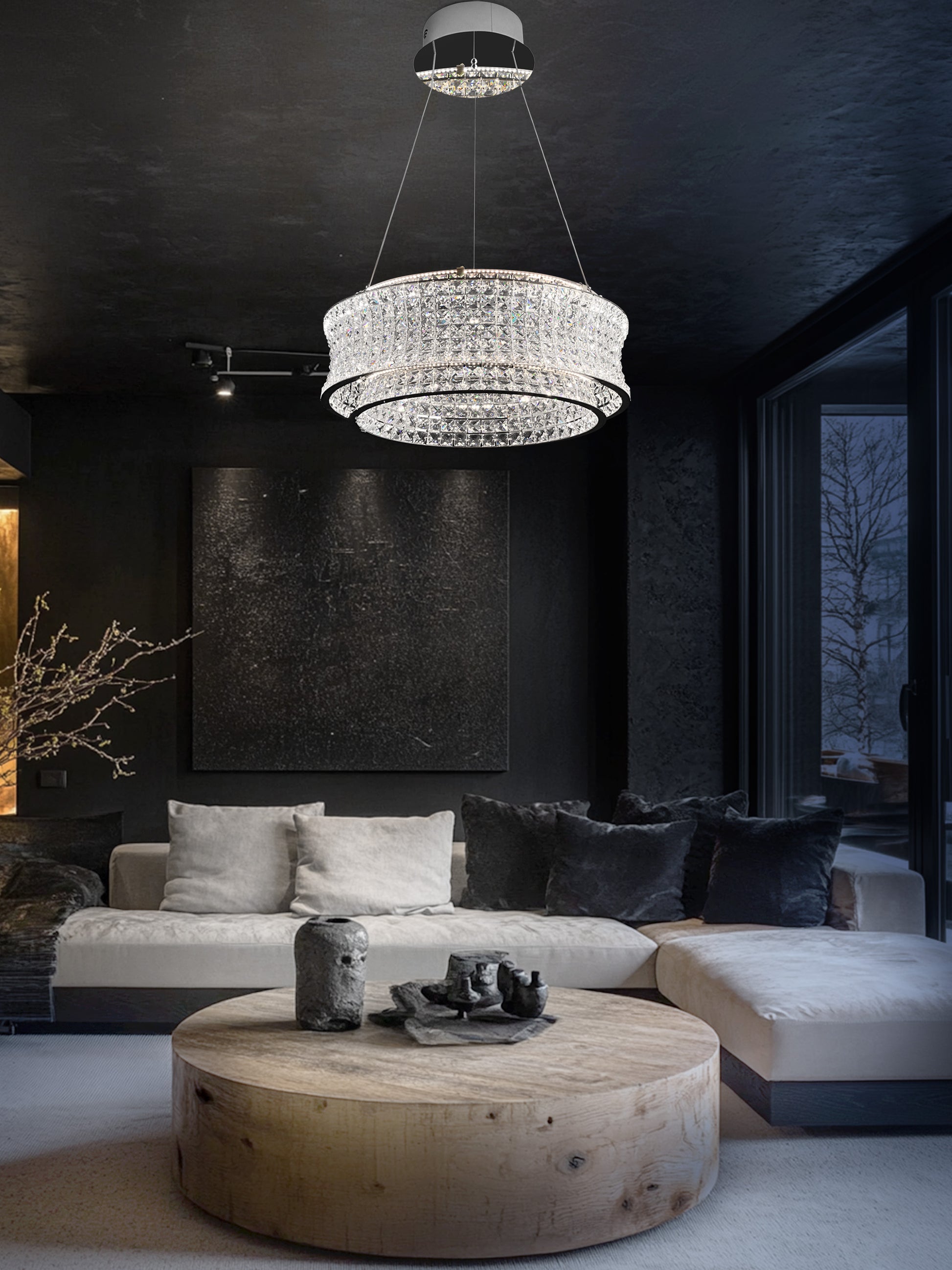 chrome crystal LED chandelier illuminating a contemporary living room with sofa and coffee table.