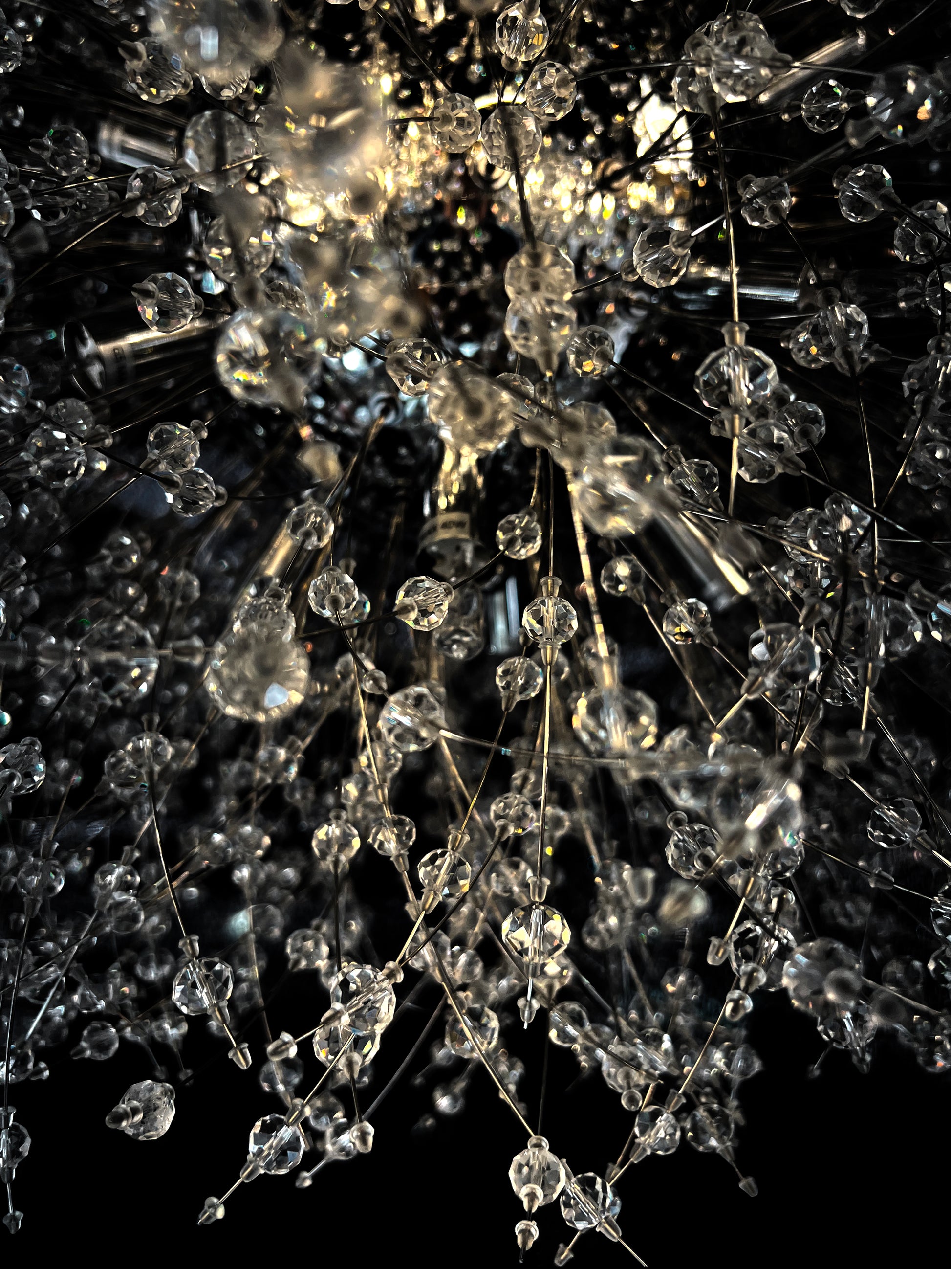 Detailed close-up of chrome starburst chandelier with sparkling crystals
