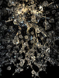 Detailed close-up of chrome starburst chandelier with sparkling crystals

