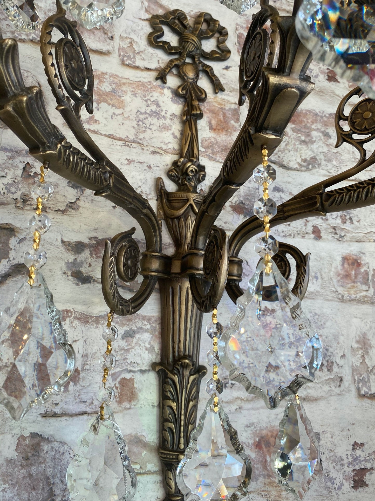 Close-up of brass candle arm with hanging clear crystals