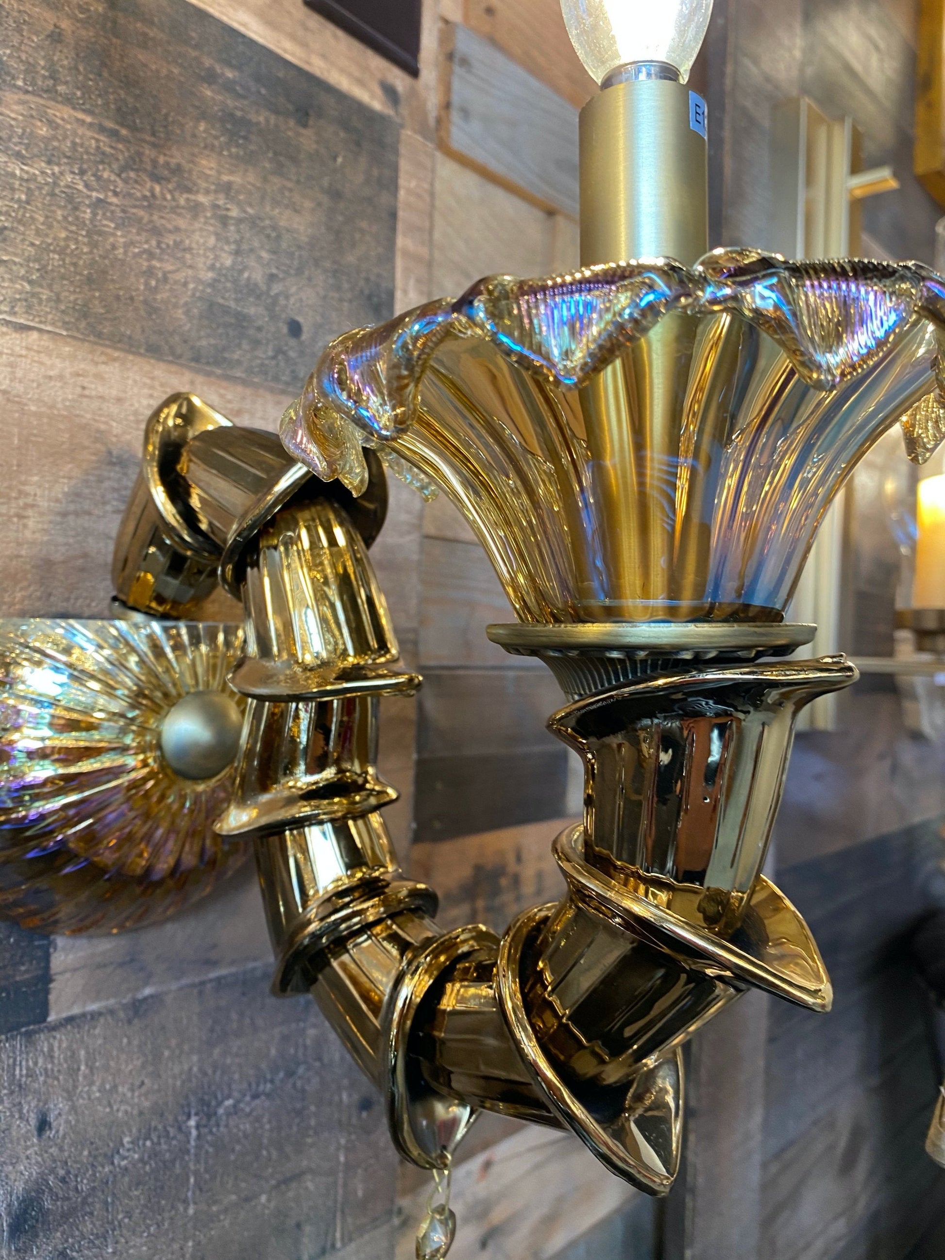 Gold wall sconce with a reflective surface