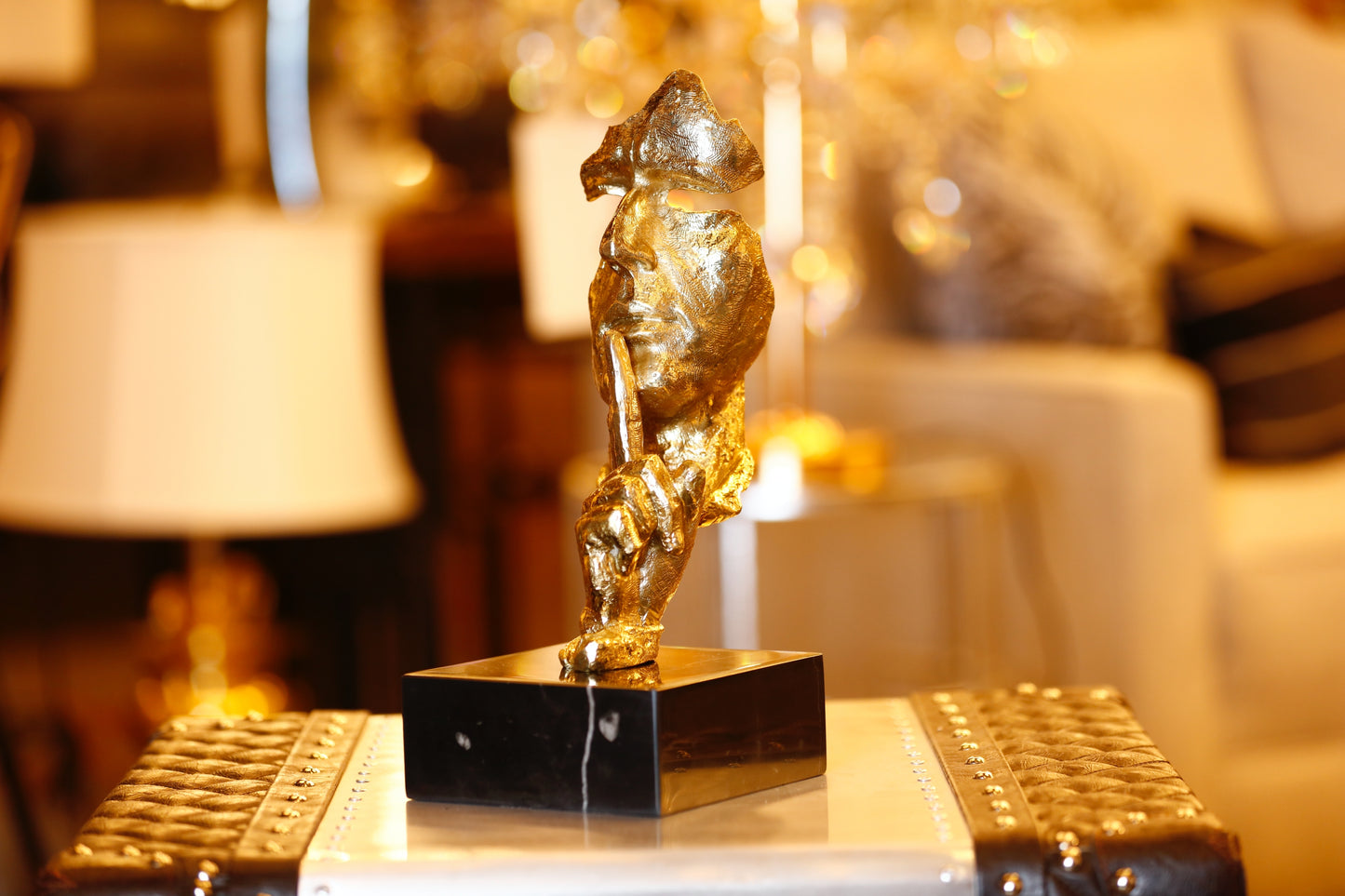  Modern handcrafted Italian solid brass Silence sculpture on a black marble base with a gold lacquer finish.