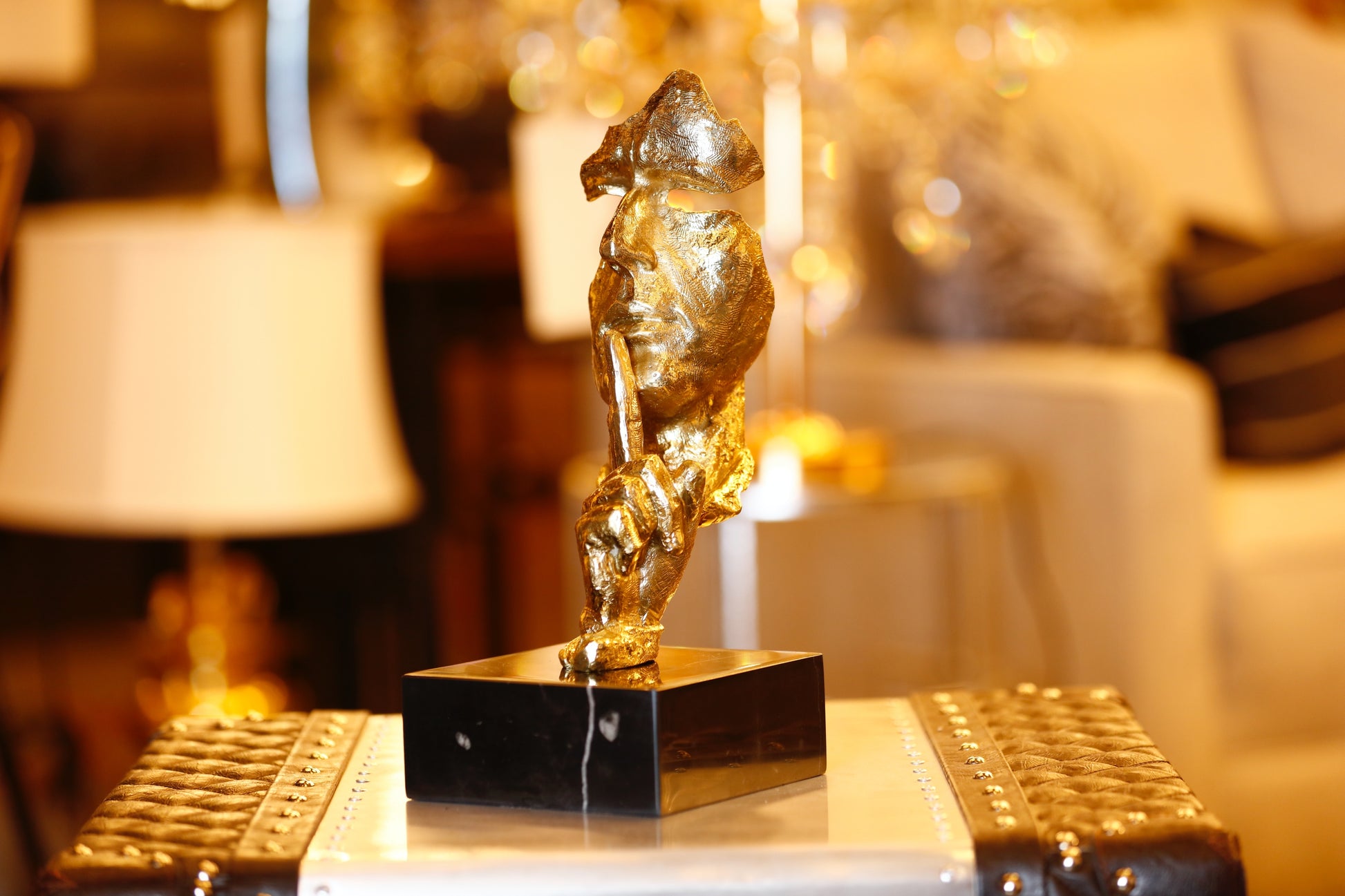  Modern handcrafted Italian solid brass Silence sculpture on a black marble base with a gold lacquer finish.