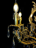 Close-up of handcrafted Italian brass chandelier arm with crystal drops and candle light