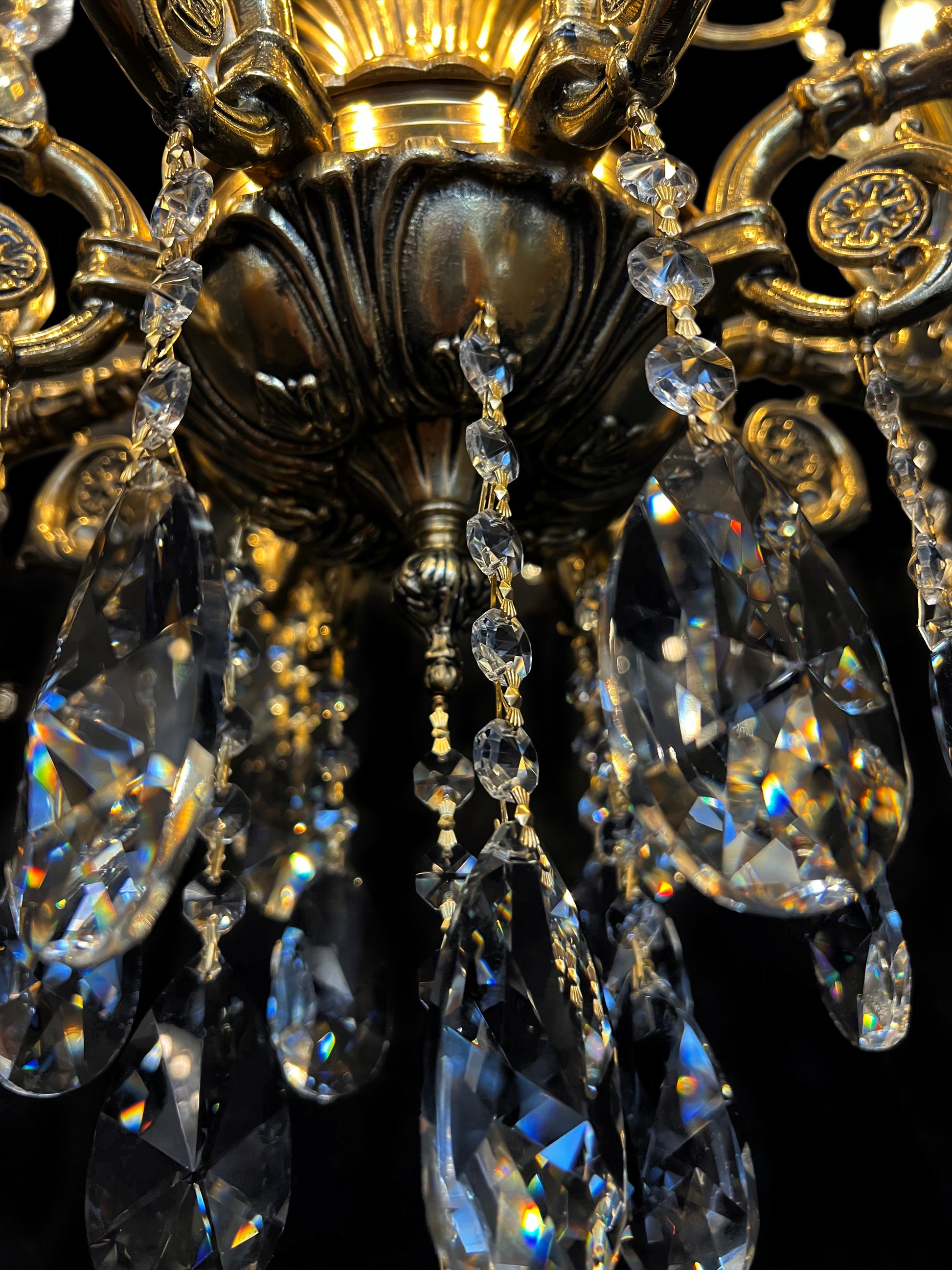 Close-up of Italian brass chandelier crystals and candle arms