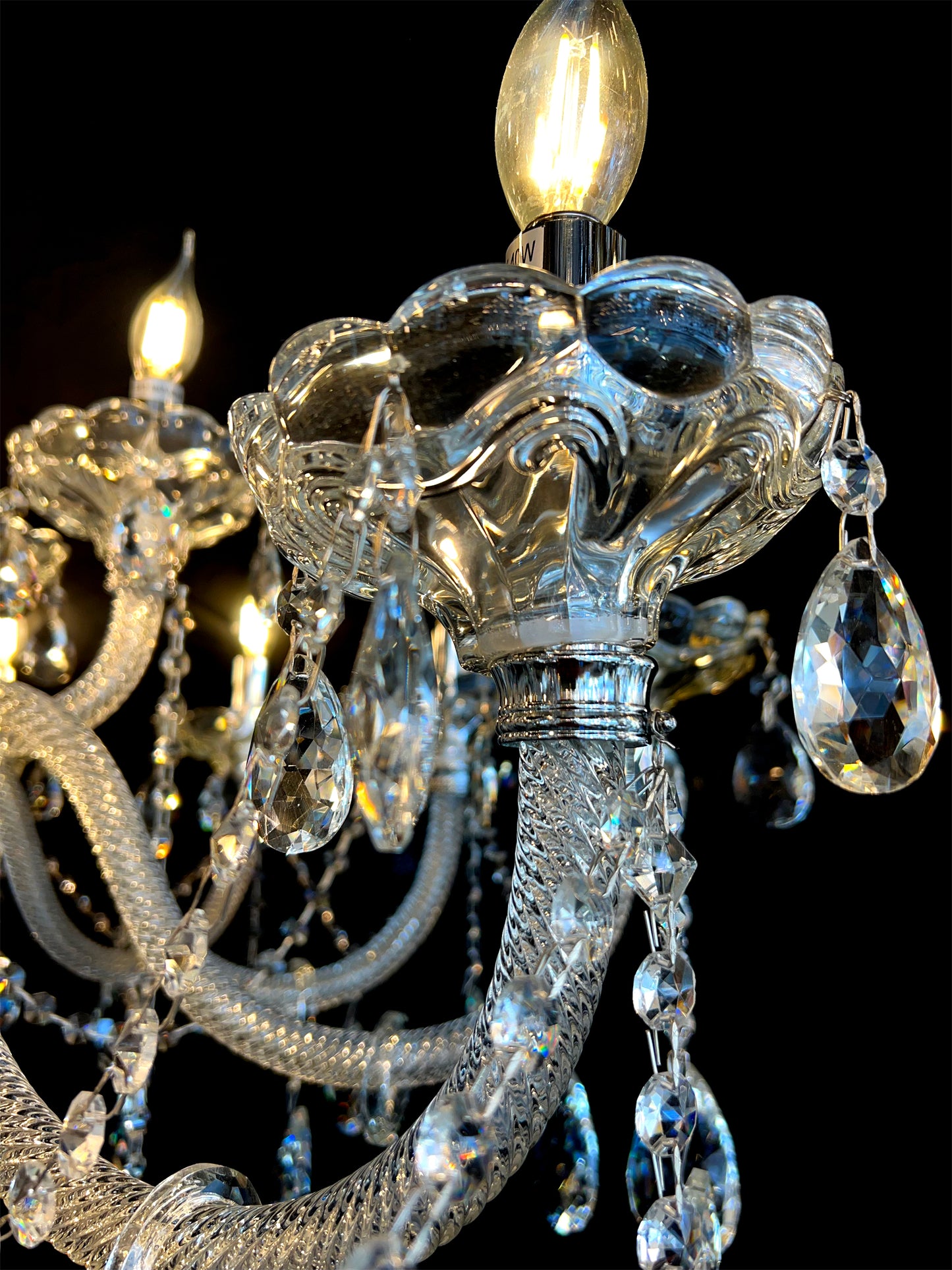 Close-up of sparkling teardrop crystals on a chrome chandelier.