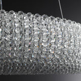 Close-up of faceted crystal beads reflecting light in a modern chandelier.