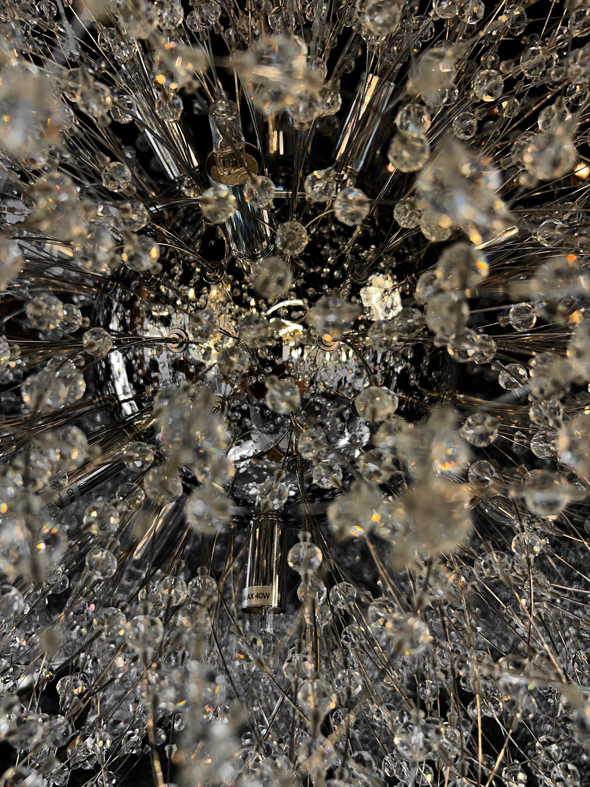 Precision-cut crystal branches detail on modern chrome chandelier