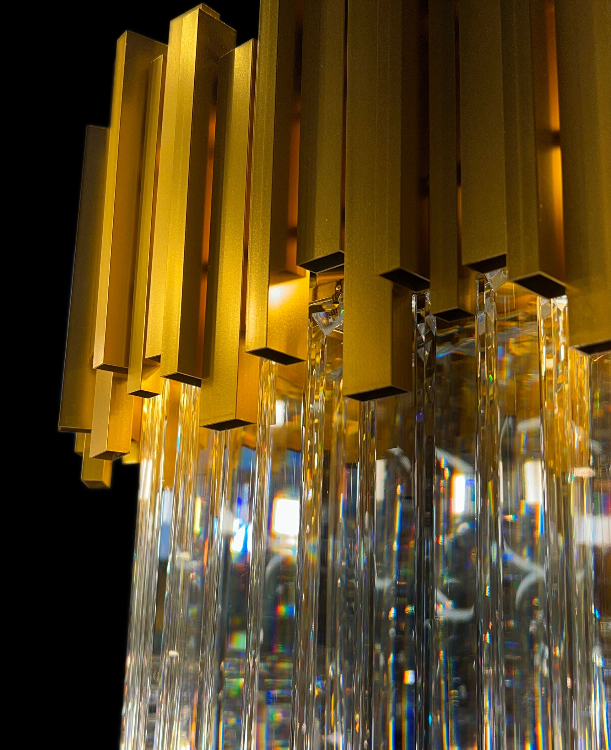 Close-up view of gold crystal linear chandelier rectangular prisms
