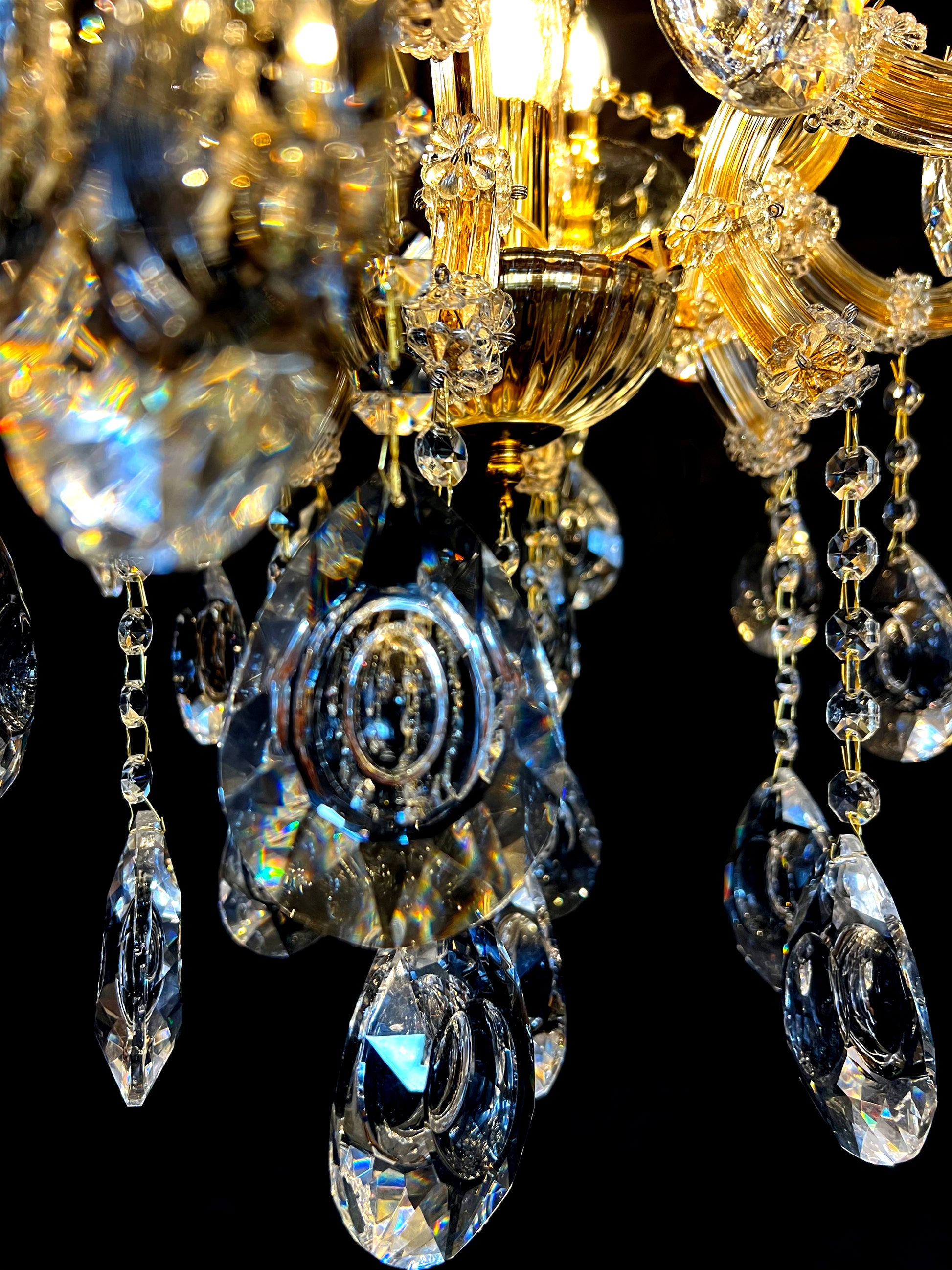 Close-up of 30% full-lead teardrop crystals on gold Maria Theresa chandelier.