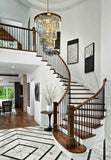 Tiered gold chandelier above staircase foyer