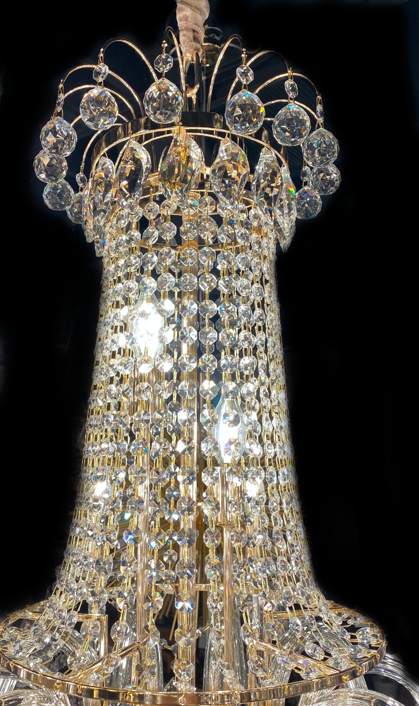Upper section of chandelier featuring teardrop and crystal chains