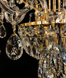 Detailed gold chandelier base with hanging crystals reflecting warm light.”