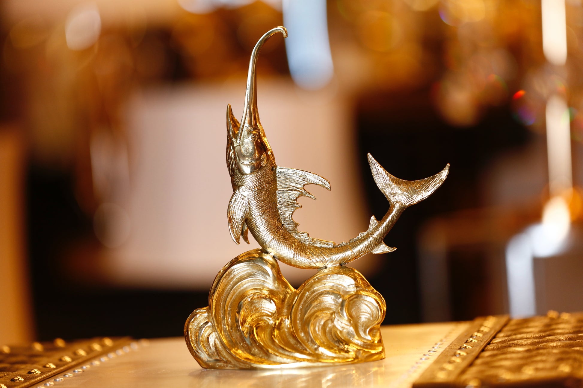 Majestic handcrafted Italian solid brass swordfish sculpture leaping over waves with a protective lacquer finish.